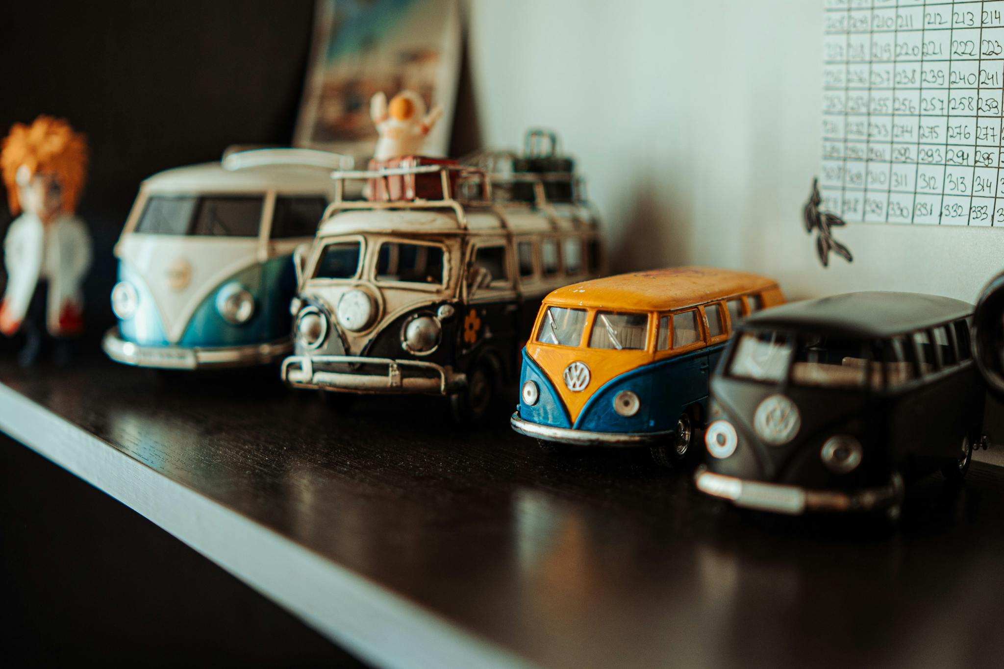 A collection of vintage Volkswagen toy cars displayed on a shelf.