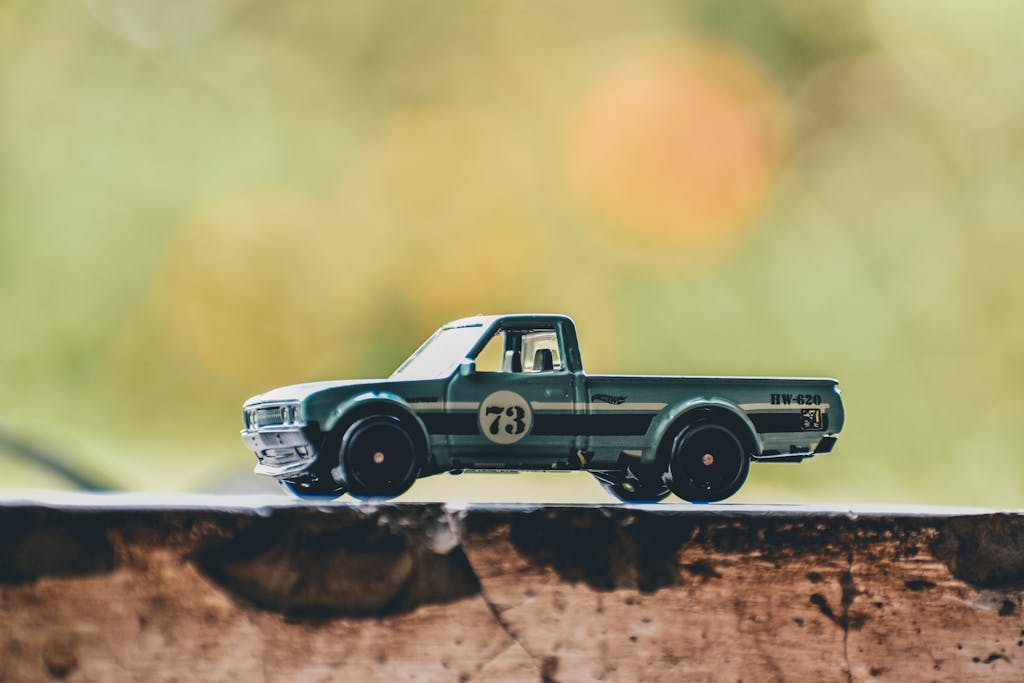 Close-up of a vintage toy truck captured with soft focus on a rustic surface outdoors.