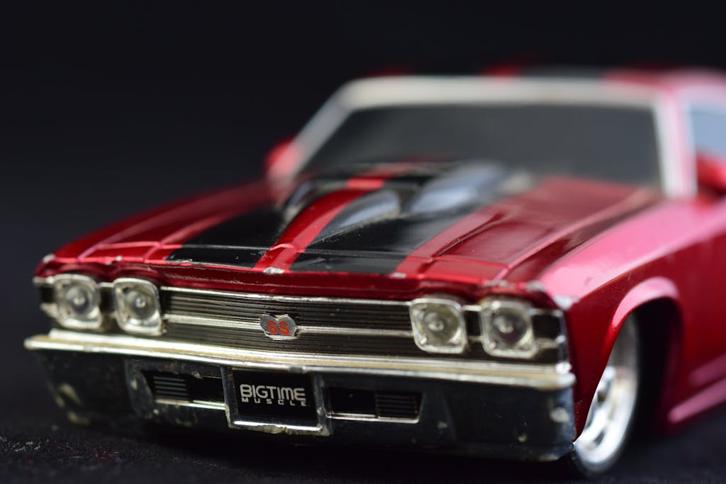 Detailed macro shot of a red classic toy car with chrome and black details.